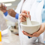 Person compounding medication in a white bowl